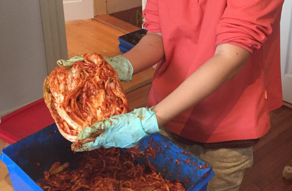 Jill holds up a finished cabbage at the end of the kimchi workshop. 